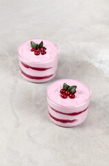 Dessert cream cheese berry, tiramisu in a glass cup on a light gray background