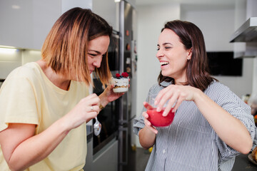 Wall Mural - Women preparing healthy food playing with vegetables in kitchen having fun concept dieting nutrition.