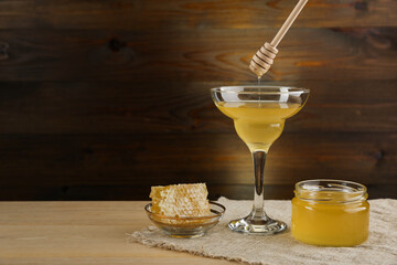 jar of honey and honeycomb are on wooden background in rustic style