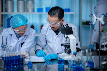 Wall Mural - group of laboratory assistants checking blood, using microscope and doing test for bacteria
