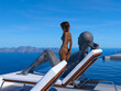 Illustration of an alien sunbathing and looking at a woman in a thong bikini near him at a resort.
