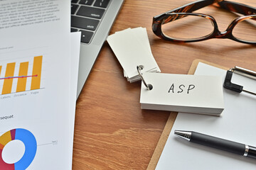 There is a piece of paper with a graph printed on it, a clipboard, and an open vocabulary book on the desk. The word ASP is there. It's an acronym that means Application Service Provider.