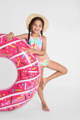 Canvas Print - Cute little child in beachwear with bright inflatable ring on white background