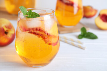 Poster - Delicious peach lemonade made with soda water on white wooden table, closeup. Space for text