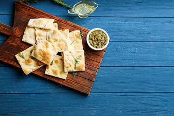 Delicious focaccia bread on blue wooden table, flat lay. Space for text