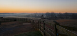 Fototapeta Na sufit - A view of a fence and weather vane during sunrise in Virginia.