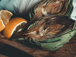 ARTICHOKE SPLIT IN HALF WITH A LEMON READY TO BE COOKED