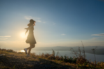 Wall Mural - Beautiful Young Woman in a field at sunset.