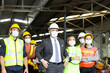 © Stella - Large group of confident industrial engineer worker and foreman boss with face mask wearing safety equipment standing at manufacturing plant factory.