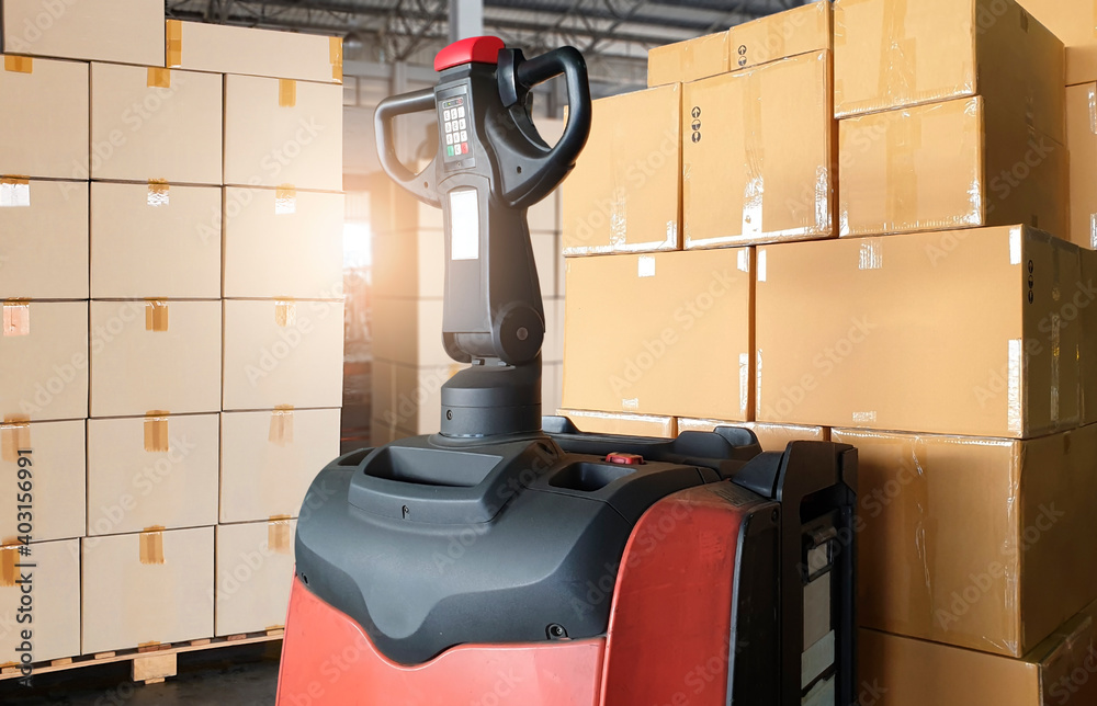 Electric forklift pallet jack with cargo shipment boxes. Stack of ...