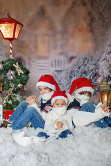 Wall Mural - Children, sitting in the snow, wrapped in toilet paper and christmas light strings