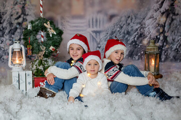 Wall Mural - Children, sitting in the snow, wrapped in toilet paper and christmas light strings