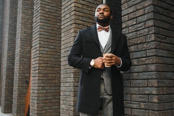 Close up portrait of a young businessman relaxing and drinking coffee in the city