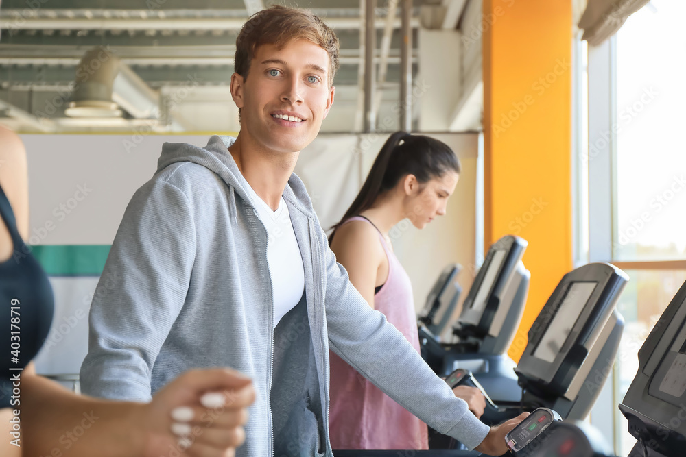 Young people training on treadmills in gym
