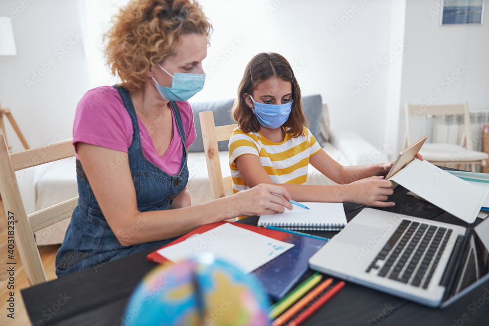 Child home studying education, homeschooling, with private tutor / mother with protective mask in the time of viruses, flu and seasonal pandemic. - obrazy, fototapety, plakaty 