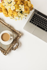 Wall Mural - Lifestyle blog, social media concept. Flatlay female minimal workspace with laptop computer, coffee cup and beautiful flowers bouquet on white table. Top view, business, work stylish composition.