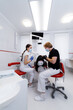 © Vadim - Dentists treat patients teeth. Modern dental clinic background. Health concept. White scrubs on medics.