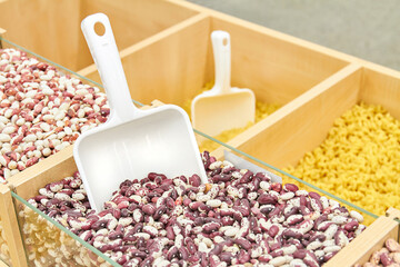 Red beans in a tray with a plastic grain spatula in a supermarket