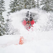 © anatoliy_gleb - Happy moments at ski resort in the mountains. Woman in vivid ski suit sitting and playing with snow, throwing it up. Concept of winter entertainment