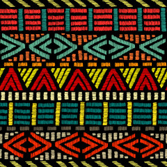 Wall Mural - Embroidered ethnic seamless pattern. Aztec and tribal motifs. Striped ornament hand drawn. Print in the bohemian style. Vector illustration.