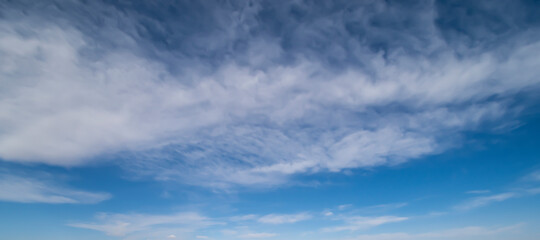 Wall Mural - Stunning view of a blue sky with white fluffy clouds during a sunny day. Natural background, wallpaper or preset with copy space.