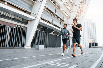 Wall Mural - European man and african american woman in sportive clothes have workout together