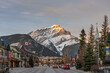Street view of Banff Avenue in autumn evening. Snow capped Cascade Mountain with pink rosy sky in the background. Alberta, Canada.