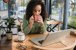 © LIGHTFIELD STUDIOS - african american woman drinking coffee from cup while looking at laptop