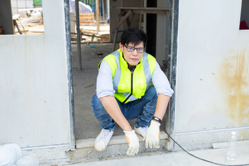 Wall Mural - Asian man construction worker looking stressed on construction site.