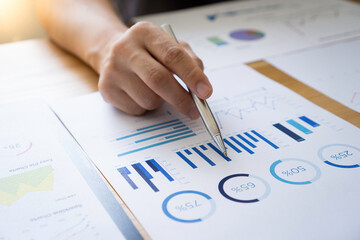 Asian male finance staff Is explaining the performance from the company's rapidly growing bar graph this year. To his boss On the desk at the office, Finance concept