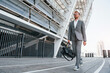 © standret - Urban beauty. Young businessman in grey formal wear is outdoors in the city