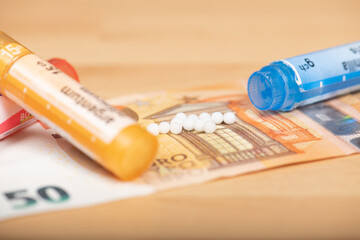 Homeopathic globules scattered around with their colored containers in the shape of tube.