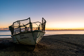 Sticker - sunset at the Praia do Pescadores on the Algarve coast of Portugal with a small fishing boat on the beach