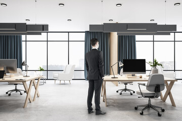Aufkleber - Businessman standing in contemporary office room with computers