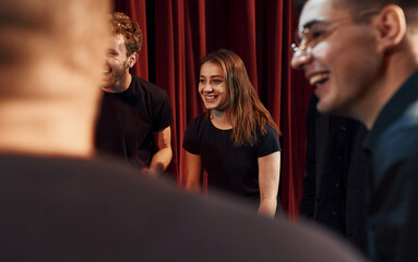 Group of actors in dark colored clothes on rehearsal in the theater