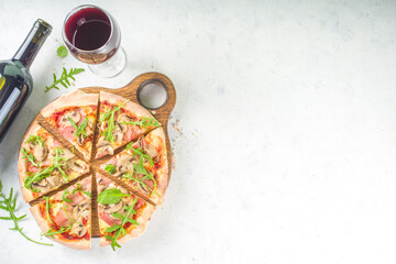 Wall Mural - Pizza party concept.  Set of pizzas with various fillings, Pieces of different pizza, glass and bottle with wine. Flatlay top view copy space on white background