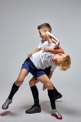 Wall Mural - two soccer players interfere with each other, compete. studio portrait of young football players