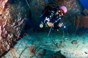 Female SCUBA diver on a tropical coral reef in the Andaman Sea, Asia