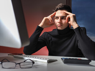 Poster - Hard mental work. Young man looks at the monitor screen and thinks. Analytical work. Business problems. Young businessman is looking for ways to solve problems. Complexity Of business planning.