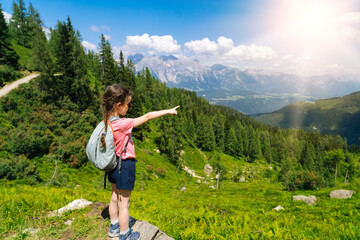 children hiking on beautiful summer day in alps mountains austria, resting on rock and admire amazin