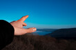 © Denis - Hand pointing to the sky. Beautiful mountain landscape.