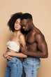 © LIGHTFIELD STUDIOS - shirtless african american man hugging woman with closed eyes isolated on beige