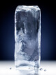 Vertical rectangular block of ice isolated on dark blue background with clipping path.