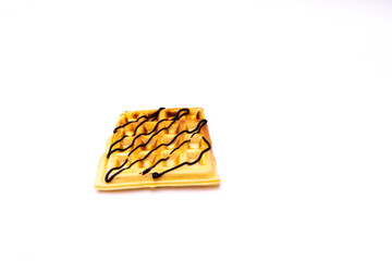 Appetizing Belgian waffle topped with chocolate topping on a white background