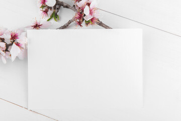 Horizontal empty card mockup with blooming almond tree branch, design element for wedding rsvp, thank you card, greeting or invitation card. Valentine's Day card for your text. Spring background