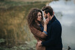 © Andriy Medvediuk - stylish hipster caucasian couple hugging at lake in autumn. man and woman in love in modern outfit