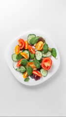 Wall Mural - White plate with a bright fresh vegetable salad of vegetables and greens on a light background