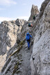Ludzie przechodzą wąską, skalną ścieżką na via ferracie, Dolomity, Włochy