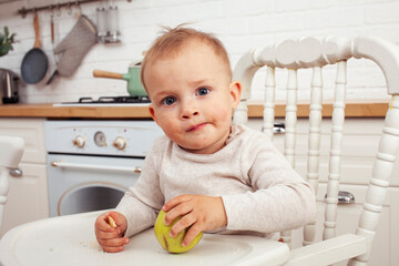 little cute boy in chair on kitchen in morning, lifestyle people concept