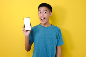 Happy Excited Young Asian man shock showing white phone screen at camera,